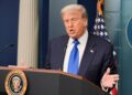 El presidente de los Estados Unidos, Donald Trump, habla con los medios de comunicación en un podio.