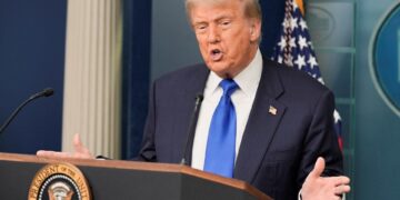 El presidente de los Estados Unidos, Donald Trump, habla con los medios de comunicación en un podio.