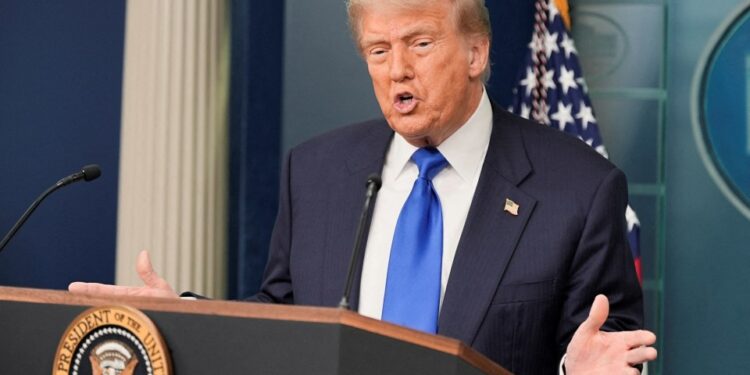 El presidente de los Estados Unidos, Donald Trump, habla con los medios de comunicación en un podio.