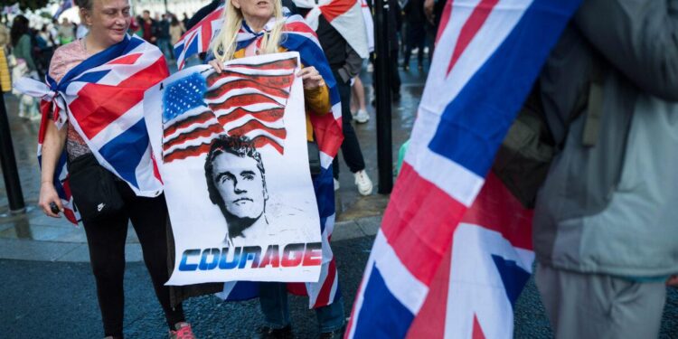 Los manifestantes llevan un póster que representa al difunto Charlie Kirk durante la manifestación