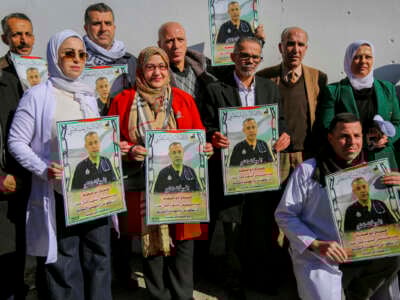 Los manifestantes sostienen pancartas y fotografías del Dr. Hossam Abu Safiya durante una sentada en Hebrón, en la Cisjordania ocupada por Israel, el 9 de enero de 2025.