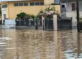 Edificios y una puerta parcialmente sumergida por aguas de inundación.