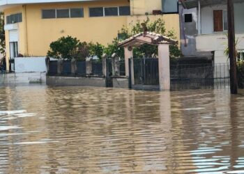 Edificios y una puerta parcialmente sumergida por aguas de inundación.
