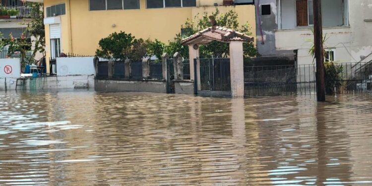 Edificios y una puerta parcialmente sumergida por aguas de inundación.