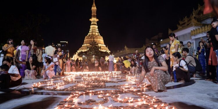 Los devotos budistas encienden lámparas de tierra en la Pagoda Botahtaung para conmemorar el día de luna llena del festival Thadingyut.