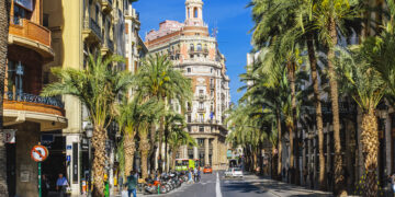 ¿Arrer de les Barques calle con palmeras en un día soleado en Valencia, España