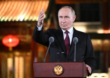 El presidente ruso, Vladimir Putin, habla en un podio con dos micrófonos y hace un gesto con la mano derecha durante una conferencia de prensa en Beijing.