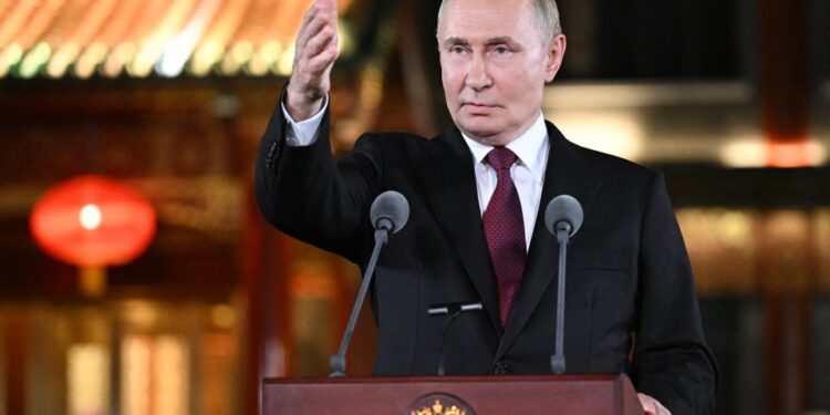 El presidente ruso, Vladimir Putin, habla en un podio con dos micrófonos y hace un gesto con la mano derecha durante una conferencia de prensa en Beijing.