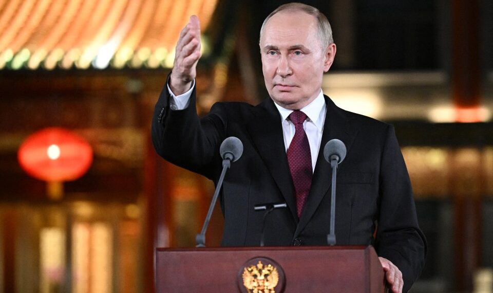 El presidente ruso, Vladimir Putin, habla en un podio con dos micrófonos y hace un gesto con la mano derecha durante una conferencia de prensa en Beijing.