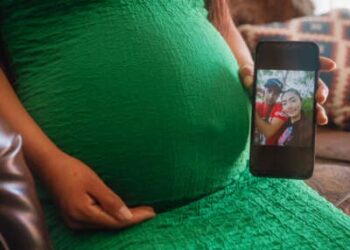 Una mujer embarazada en Dallas, Texas, muestra una fotografía de ella y su pareja, que recientemente fue detenida por la aplicación de inmigración y aduana (ICE) de Estados Unidos durante un registro, el 20 de marzo de 2025.