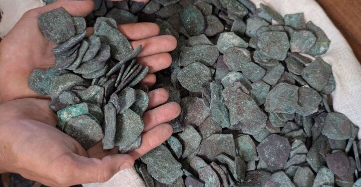 Las manos que sostienen monedas de oro y plata recuperadas del naufragio de la flota del tesoro de 1715.