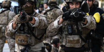 Los agentes de aduanas y protección fronteriza de los Estados Unidos se mantienen "menos letal" Armas frente al edificio federal durante las manifestaciones en curso en respuesta a las operaciones federales de inmigración en el centro de Los Ángeles el 12 de junio de 2025.