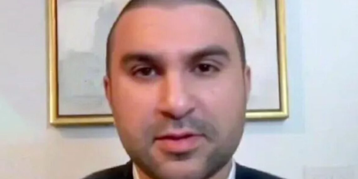 Un collage de imágenes que contiene 1 imagen. La imagen 1 muestra a Sami Hamdi, un hombre con la cabeza rapada y barba ligera, vestido con chaqueta y camisa con cuello.