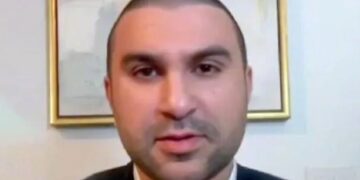 Un collage de imágenes que contiene 1 imagen. La imagen 1 muestra a Sami Hamdi, un hombre con la cabeza rapada y barba ligera, vestido con chaqueta y camisa con cuello.