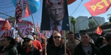 Un activista sostiene un cartel que representa al presidente estadounidense Donald Trump con cuernos de diablo durante una protesta en defensa de la soberanía nacional tras los impuestos y sanciones comerciales del gobierno estadounidense a Brasil, cerca del consulado estadounidense, en Sao Paulo, Brasil, el 1 de agosto de 2025.