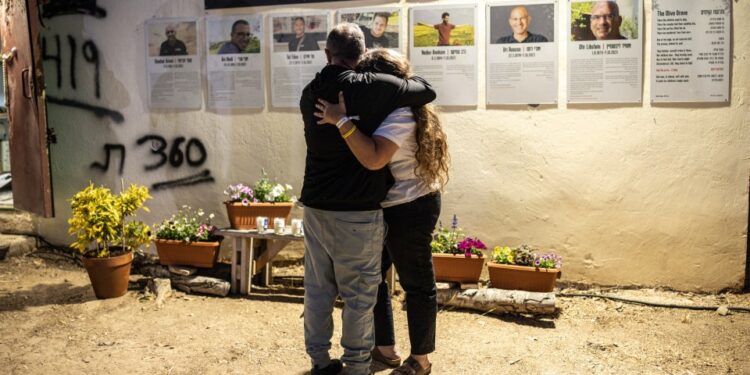 Dos personas se abrazan en una ceremonia conmemorativa para las víctimas de los ataques del 7 de octubre de 2023 en los terrenos del Festival Nova.