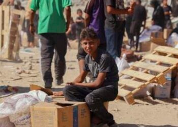 La gente camina por una calle muy dañada en Khan Younis, al sur de la Franja de Gaza, el 12 de octubre de 2025. La ayuda entró en Gaza a través del cruce de Kerem Shalom hacia Khan Younis, donde los residentes se apresuraron a apoderarse de suministros en medio de la escasez constante.