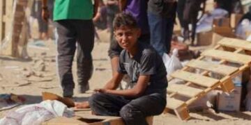 La gente camina por una calle muy dañada en Khan Younis, al sur de la Franja de Gaza, el 12 de octubre de 2025. La ayuda entró en Gaza a través del cruce de Kerem Shalom hacia Khan Younis, donde los residentes se apresuraron a apoderarse de suministros en medio de la escasez constante.