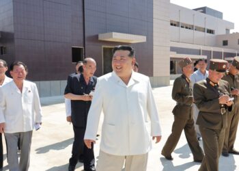 El líder norcoreano Kim Jong Un sonriendo mientras visita a sitios de construcción de varias fábricas industriales.