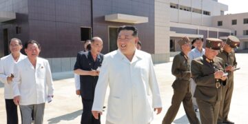 El líder norcoreano Kim Jong Un sonriendo mientras visita a sitios de construcción de varias fábricas industriales.