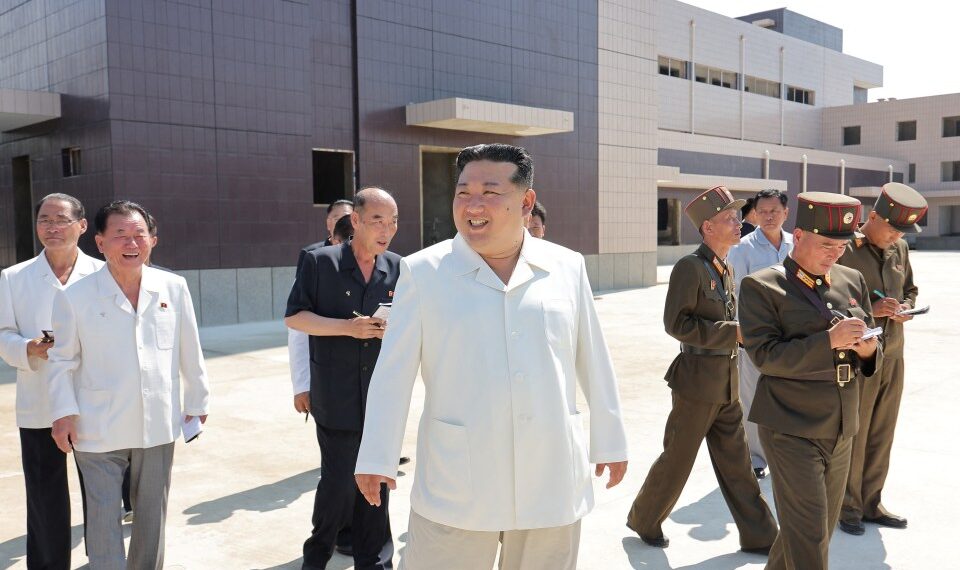 El líder norcoreano Kim Jong Un sonriendo mientras visita a sitios de construcción de varias fábricas industriales.