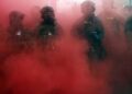 Los agentes federales despliegan una granada de humo fuera de una instalación de Inmigración y Control de Aduanas de los Estados Unidos (ICE) el 4 de octubre de 2025 en Portland, Oregon. La instalación se ha convertido en un punto focal de protestas nocturnas contra la administración Trump y su anuncio de que enviará tropas de la Guardia Nacional a Portland.