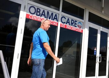 Un hombre cerca de una oficina con un cartel sobre Obamacare, o la Ley de Atención Médica Asequible, en Miami, Florida, en una fotografía de archivo sin fecha. (Joe Raedle/Getty Images)