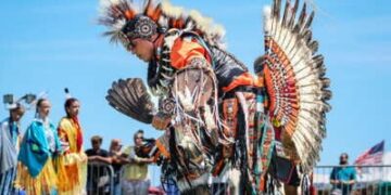 Jonathan Baca del norte de Colorado, en el centro, bailando con otros nativos americanos durante el 43º Paumanauke Pow Wow en Tanner Park en Copiague, Nueva York, el 9 de agosto de 2025.