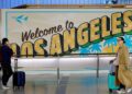 Los viajeros cerca de un "Bienvenido a Los Ángeles" Regístrate en la terminal internacional del Aeropuerto Internacional de Los Ángeles.