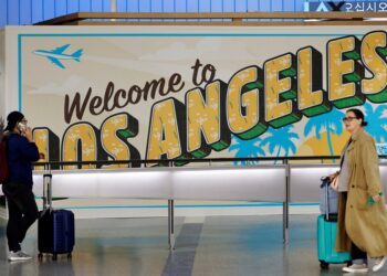 Los viajeros cerca de un "Bienvenido a Los Ángeles" Regístrate en la terminal internacional del Aeropuerto Internacional de Los Ángeles.