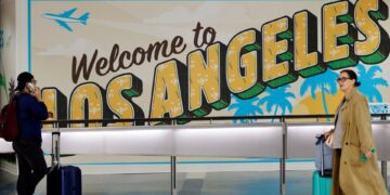 Los viajeros cerca de un "Bienvenido a Los Ángeles" Regístrate en la terminal internacional del Aeropuerto Internacional de Los Ángeles.