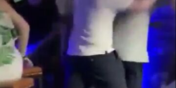 Una pelea en un bar con gente peleando y gritando.