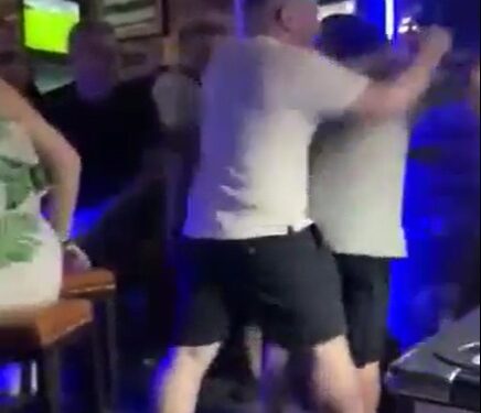 Una pelea en un bar con gente peleando y gritando.