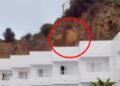 La roca cae de un acantilado sobre un edificio blanco en Ibiza.