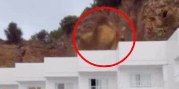 La roca cae de un acantilado sobre un edificio blanco en Ibiza.