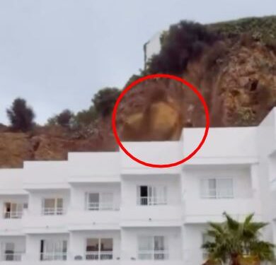 La roca cae de un acantilado sobre un edificio blanco en Ibiza.