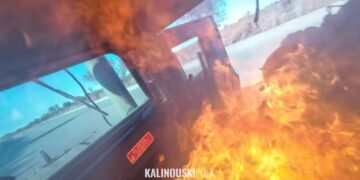 Un vehículo en llamas, visto desde el interior, con llamas que oscurecen parte del parabrisas.