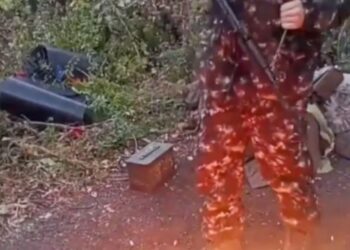 Aiden Minnis quemando un pasaporte del Reino Unido en el suelo.