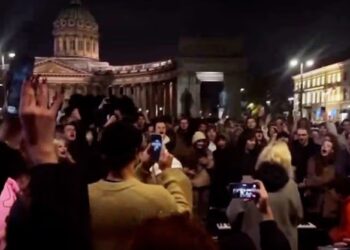 Un collage de imágenes que contiene 1 imágenes. La imagen 1 muestra una multitud de personas filmando un concierto nocturno frente a la Catedral de Kazán.