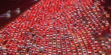 Vista aérea de una autopista de varios carriles llena de automóviles que se incorporan a ella.