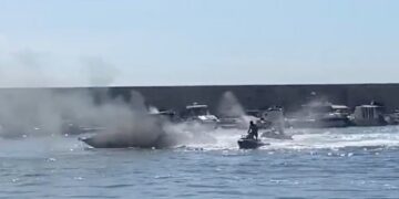 Una moto de agua ayuda a los bomberos a apagar un bote, creando un gran penacho de humo.