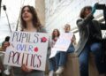 (LR) Los estudiantes de la Universidad de George Washington Eveline Straub, Kaitlyn Gang y Sonia Lerner tienen un cartel junto a Julie Byrne durante el "Manos fuera de nuestras escuelas" Rally frente al Departamento de Educación de los Estados Unidos el 4 de abril de 2025, en Washington, D/C. Estudiantes de la Universidad de Georgetown, la Universidad de Howard, la Universidad Americana, la Universidad de George Washington, la Universidad de George Mason y la Universidad del Temple se reunieron para protestar al presidente Donald Trump, desmantelamiento del Departamento de Educación de los Estados Unidos.