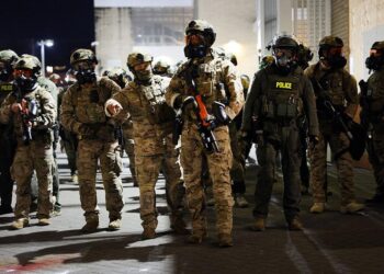 Agentes federales, incluidos miembros del Departamento de Seguridad Nacional, la Patrulla Fronteriza y la policía, intentan mantener a los manifestantes afuera de una instalación del Servicio de Inmigración y Control de Aduanas de EE. UU. en Portland, Oregon, el 5 de octubre de 2025. (Spencer Platt/Getty Images)