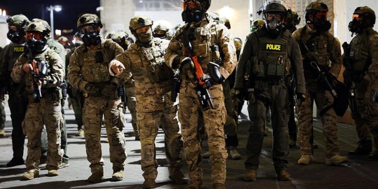 Agentes federales, incluidos miembros del Departamento de Seguridad Nacional, la Patrulla Fronteriza y la policía, intentan mantener a los manifestantes afuera de una instalación del Servicio de Inmigración y Control de Aduanas de EE. UU. en Portland, Oregon, el 5 de octubre de 2025. (Spencer Platt/Getty Images)