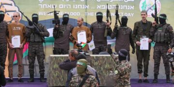 Ohad Ben Ami, Eli Sharabi, y / o Levy, con certificados, escoltados por los combatientes de Hamas en un escenario en Deir El-Balah, Central Gaza.