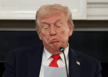 Donald Trump haciendo pucheros ante un micrófono.