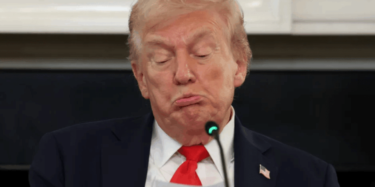 Donald Trump haciendo pucheros ante un micrófono.