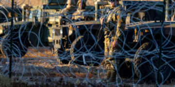 Los soldados de la Guardia Nacional de Texas están al guardia detrás del cable de concertina en la frontera entre Estados Unidos y México el 21 de diciembre de 2022, como se ve en Ciudad Juárez, México.