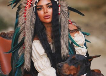 Semanur Arslan posando con un Doberman Pinscher.