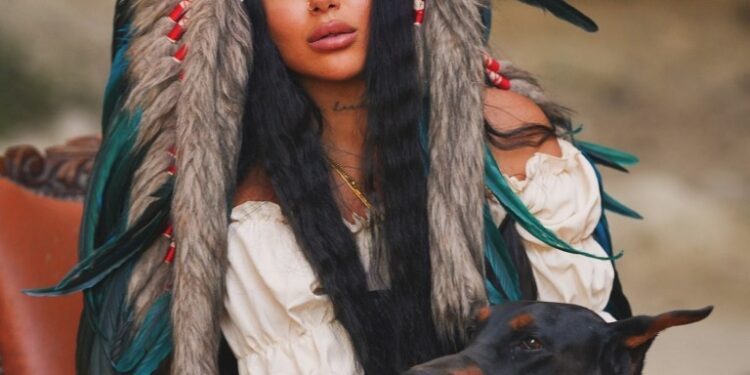 Semanur Arslan posando con un Doberman Pinscher.